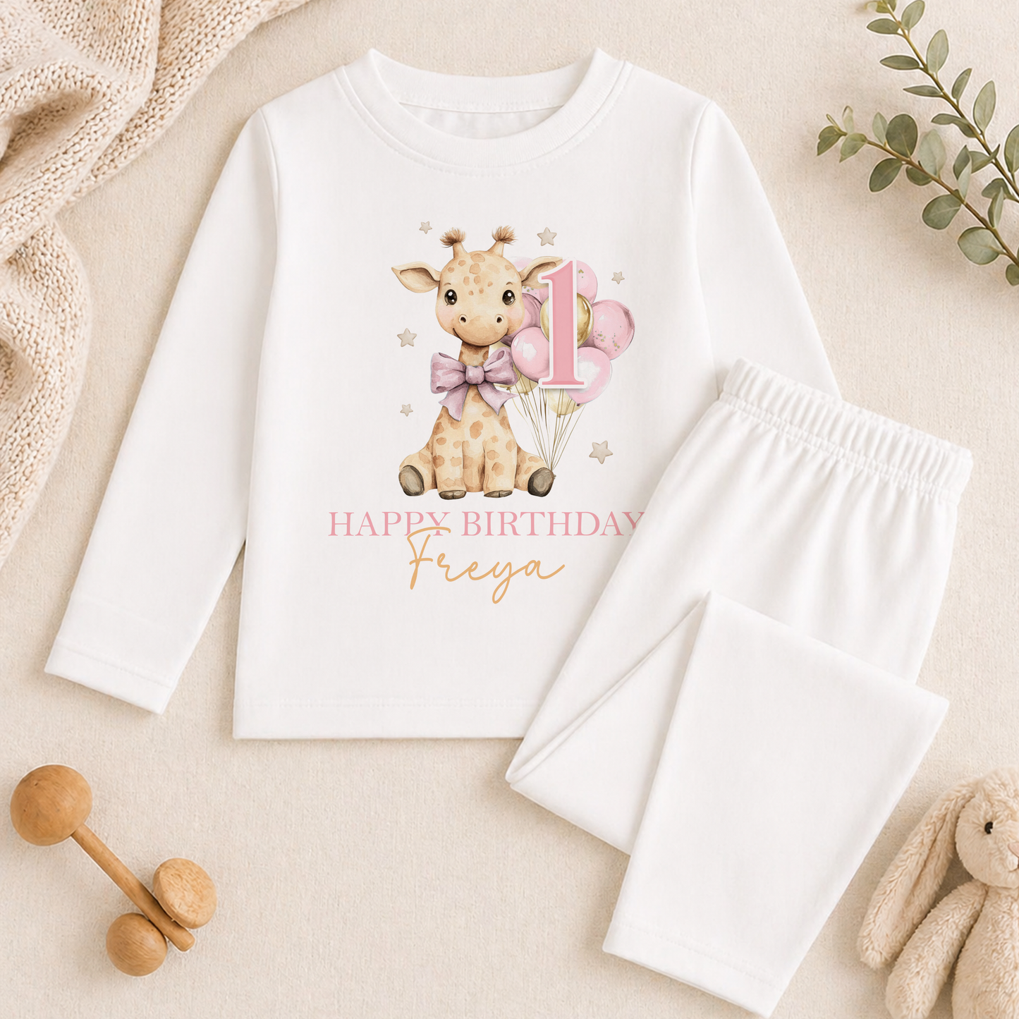 Long-sleeved top and white pyjama trousers from the giraffe birthday set, printed with a giraffe, a number 1 and 'Happy Birthday Freya'.