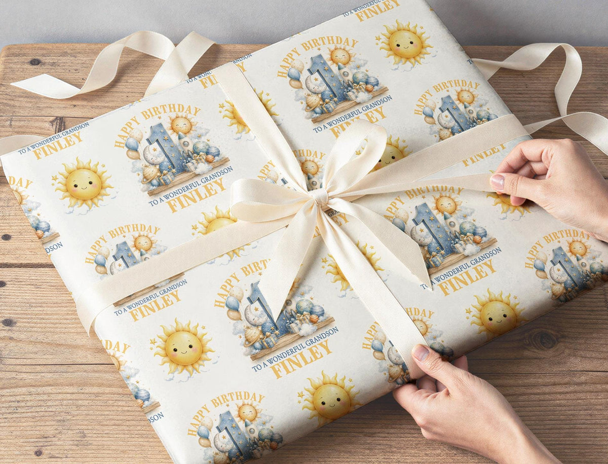 Gift wrapped in personalised sun, moon and rocket 1st birthday wrapping paper with custom name