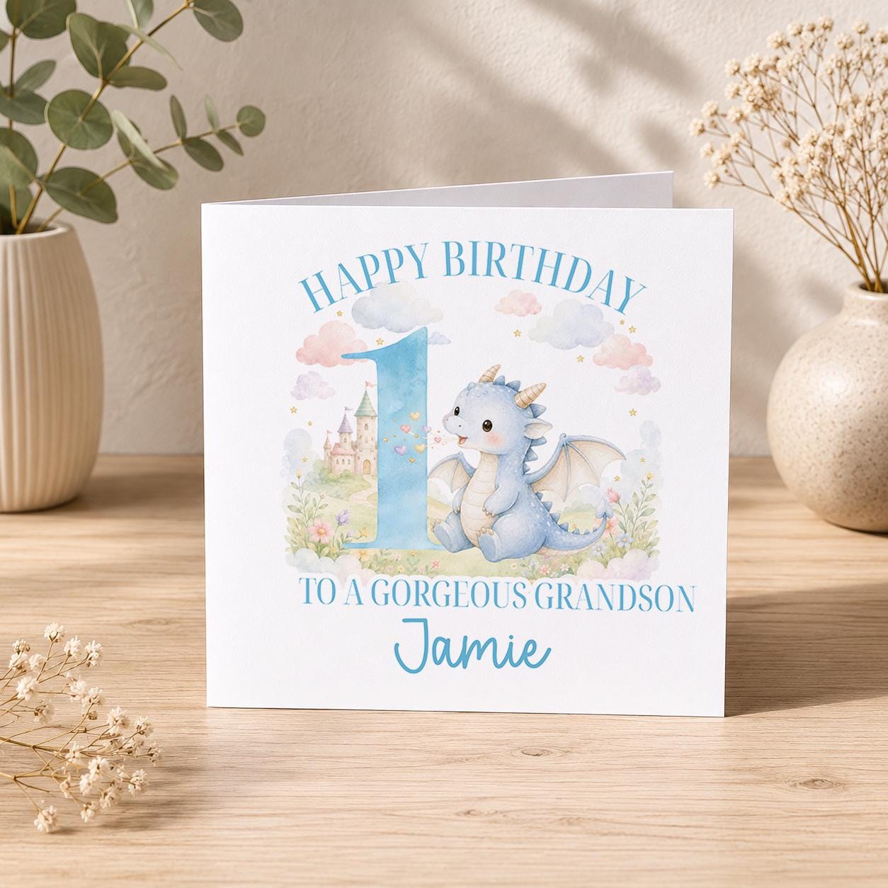 Square 1st birthday card featuring a blue dragon illustration and a large number one, personalised with a boy's name.