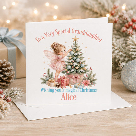 Personalised fairy Christmas card, white 6x6 inch square card printed with a fairy decorating a pink Christmas tree with a name