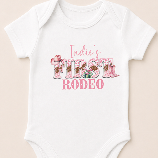 Personalised pink cowgirl first rodeo baby vest, printed with your baby's name and western cactus design.