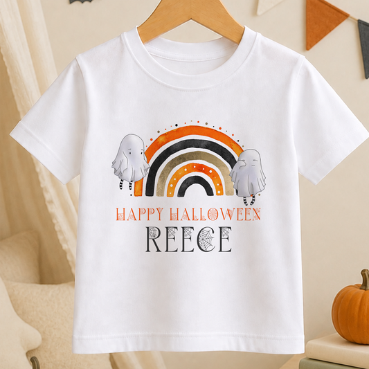 A white t-shirt with a Halloween-themed graphic design, including a rainbow and two ghostly figures. The text on the t-shirt reads "Happy Halloween" and "Reece".