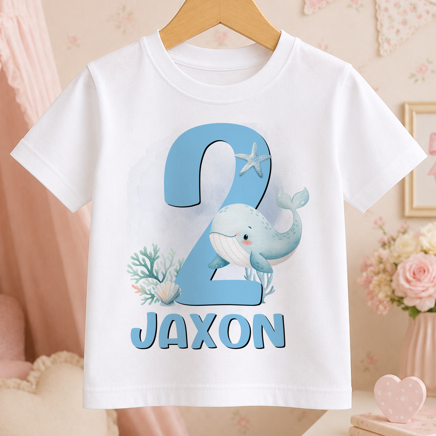 A white t-shirt with a blue whale and coral design, along with the text "JAXON" printed on it.