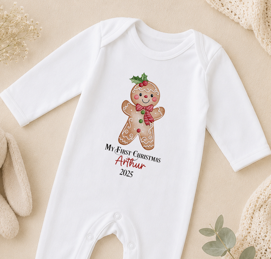 A white onesie with a gingerbread man design and text that says "My first Christmas Arthur 2020" printed on it.