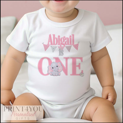 Personalised pink elephant 1st birthday bib, printed with baby's name and a bunting and daisy design.