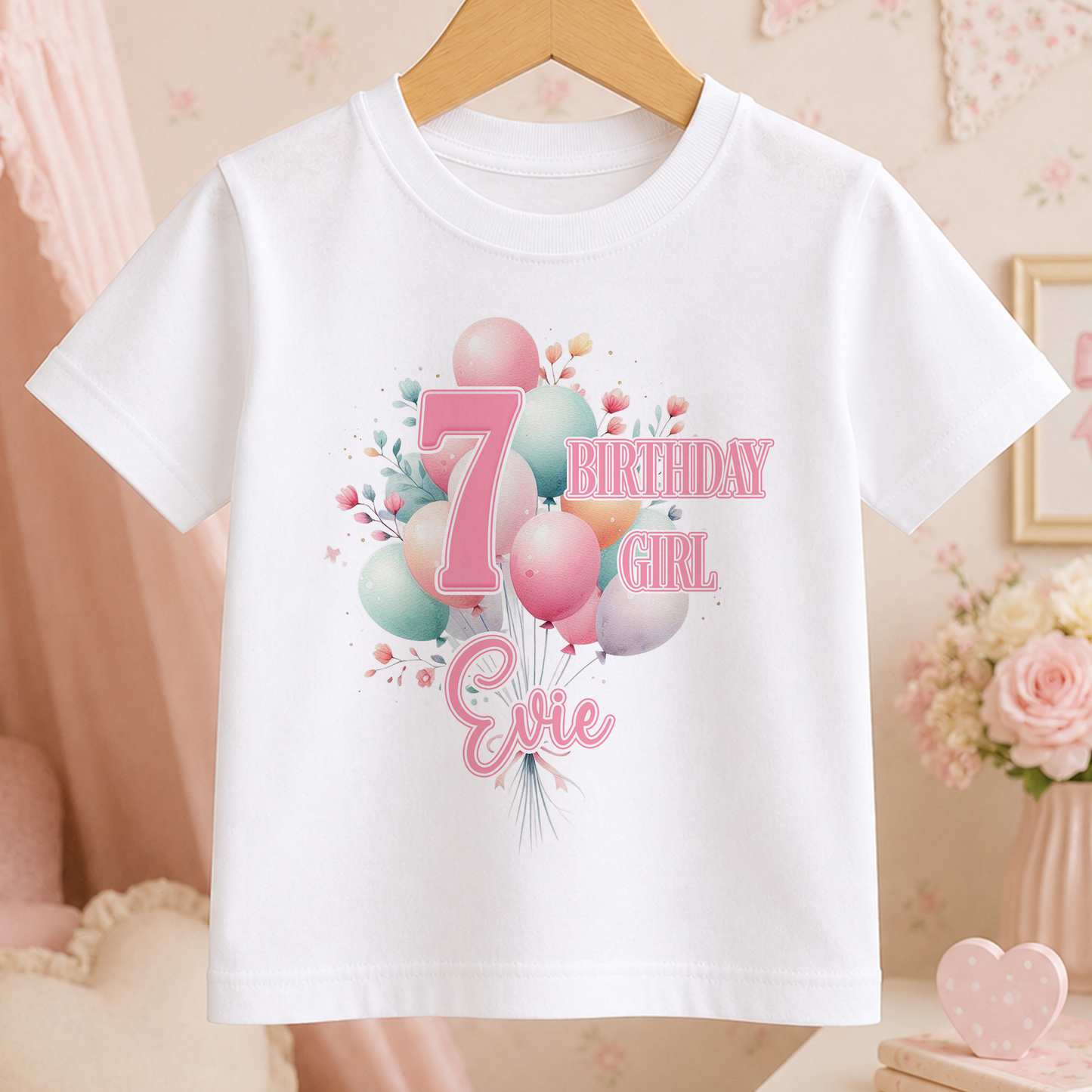 A white t-shirt with a birthday-themed design, including balloons and the text "7 BIRTHDAY GIRL Evie".