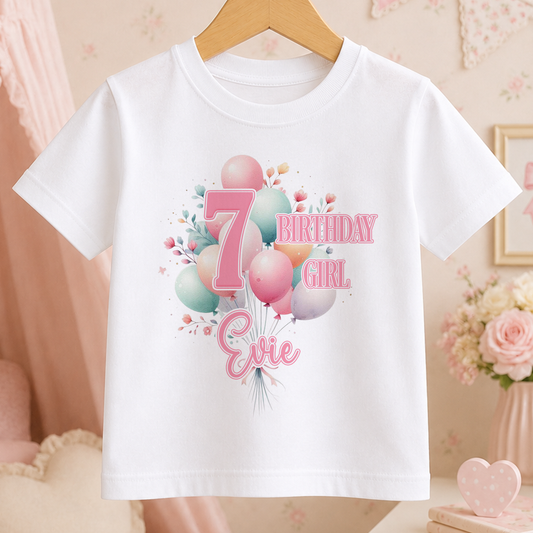 A white t-shirt with a birthday-themed design, including balloons and the text "7 BIRTHDAY GIRL Evie".