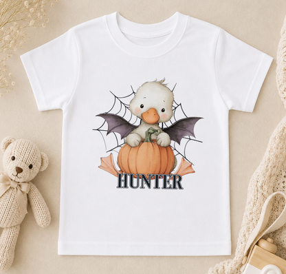 A white t-shirt with a cartoon image of a duck holding a pumpkin and a spider web, with the word "Hunter" written below.