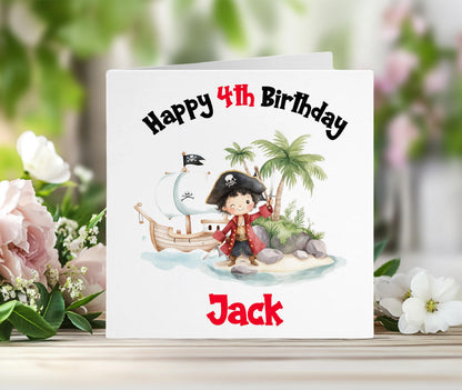 Personalised pirate birthday card with a colourful pirate ship and island scene, and the child's custom name printed in red on the front