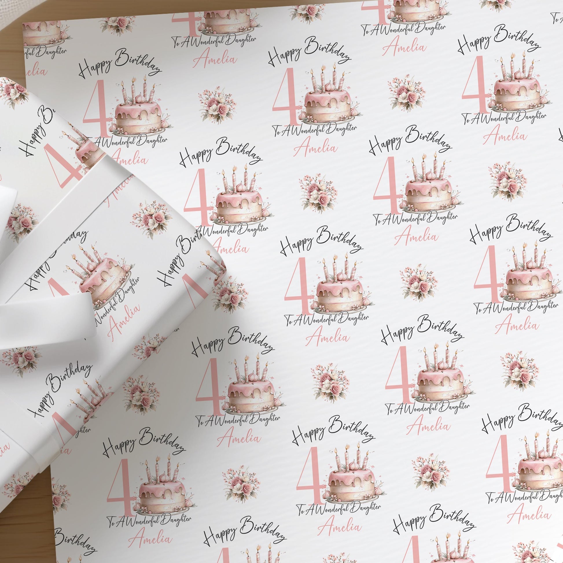 Close-up of the personalised pink birthday cake wrapping paper with floral accents, custom name and age, for a daughter's birthday