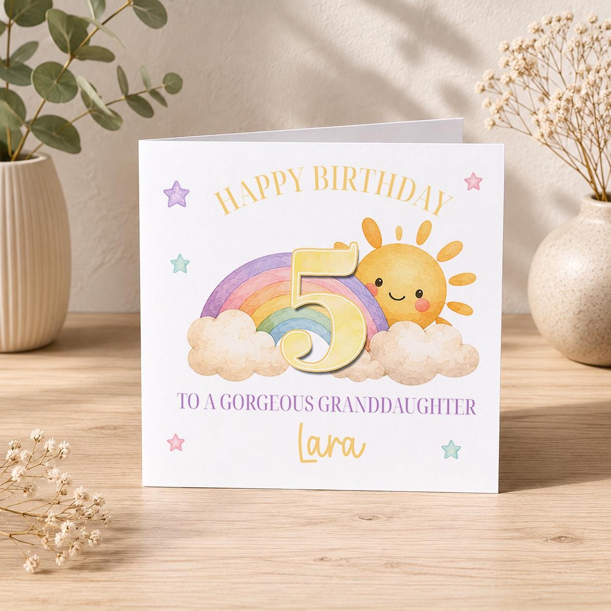 Square birthday card with a rainbow and sunshine design, personalised with a child's name, age and relation.