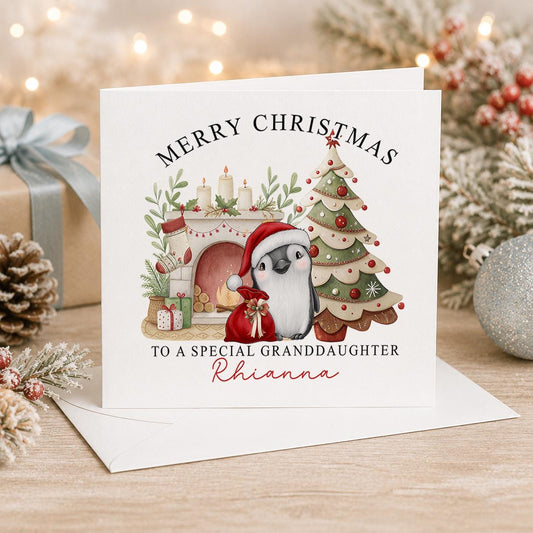 Personalised penguin Christmas card, white 6x6 inch square card printed with a penguin beside a fireplace and Christmas tree with a name
