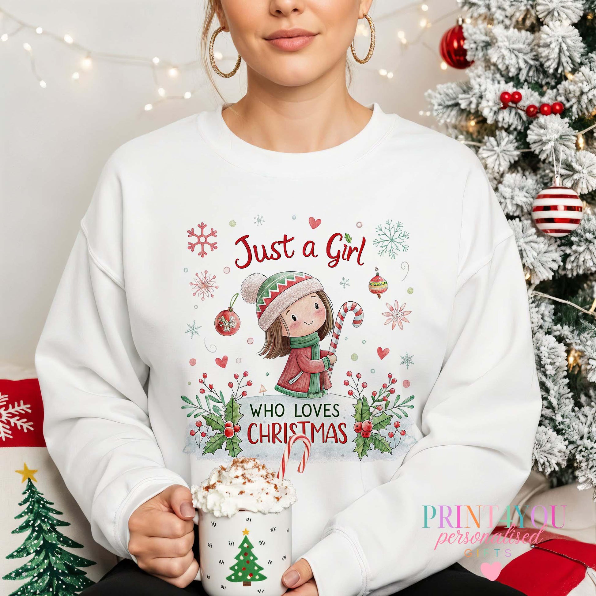 Woman wearing a white Christmas jumper printed with a 'Just a Girl Who Loves Christmas' girl-and-candy-cane design, holly and snowflakes