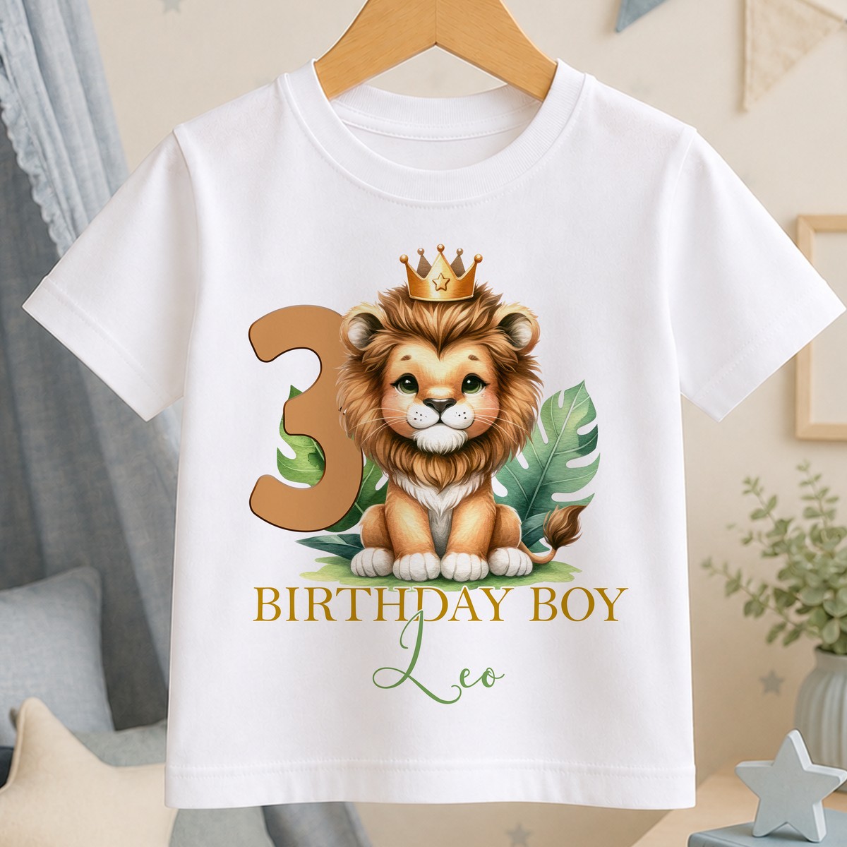 A white t-shirt with a cartoon lion wearing a crown and the number 3, along with the text "BIRTHDAY BOY Leo".