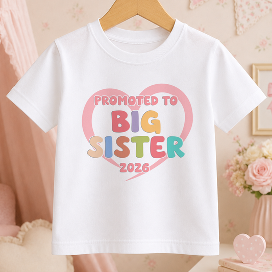 A white t-shirt with a heart-shaped graphic and text that says "Promoted to Big Sister 2026".