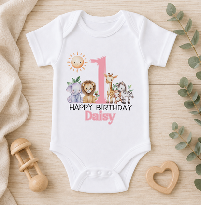 A white onesie with a pink number 1 and a design of various animals, including a lion, giraffe, and elephant, along with the text "Happy Birthday Daisy".
