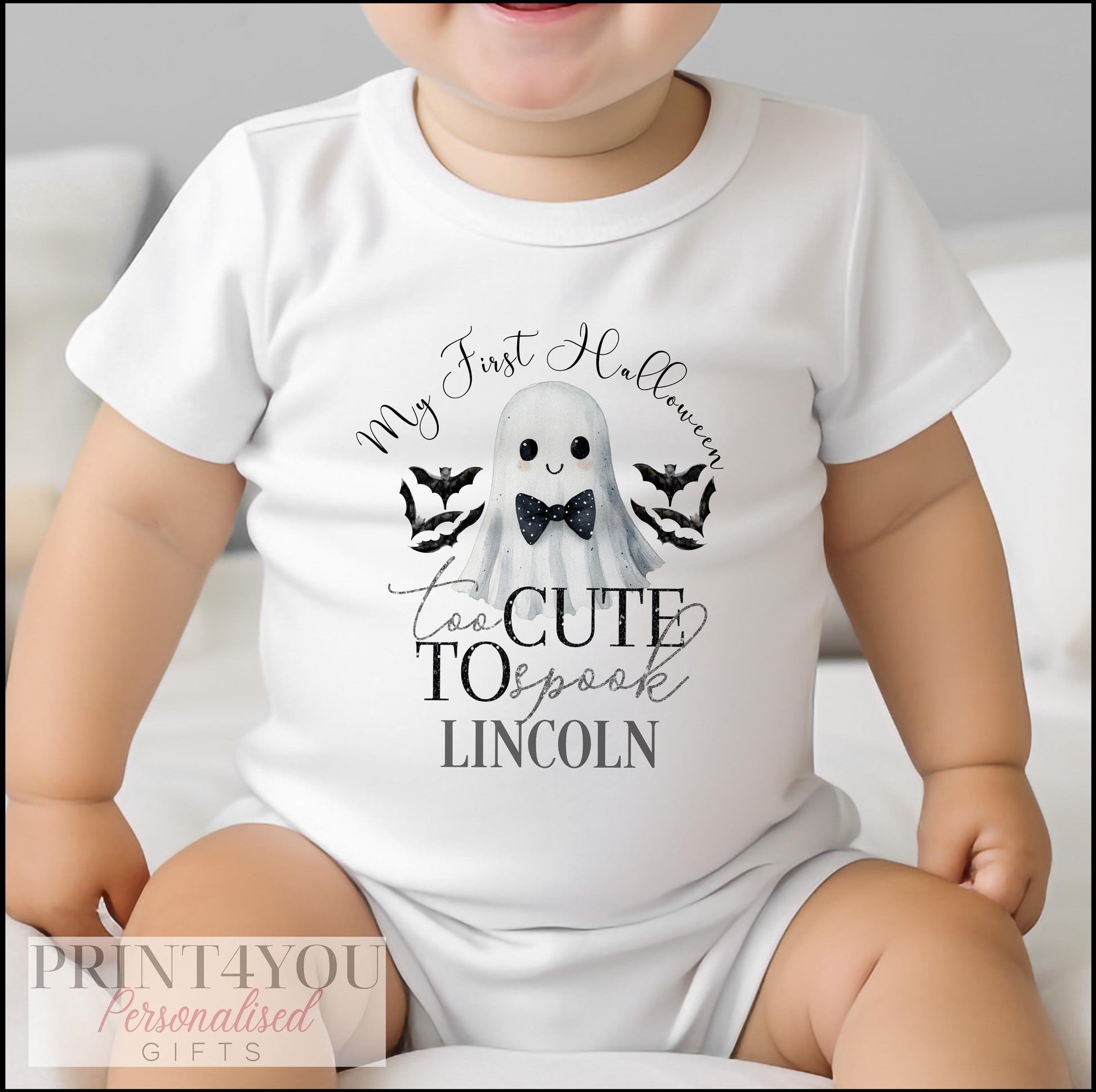Close-up of the bow-tie ghost and bats print on a personalised Halloween baby vest.