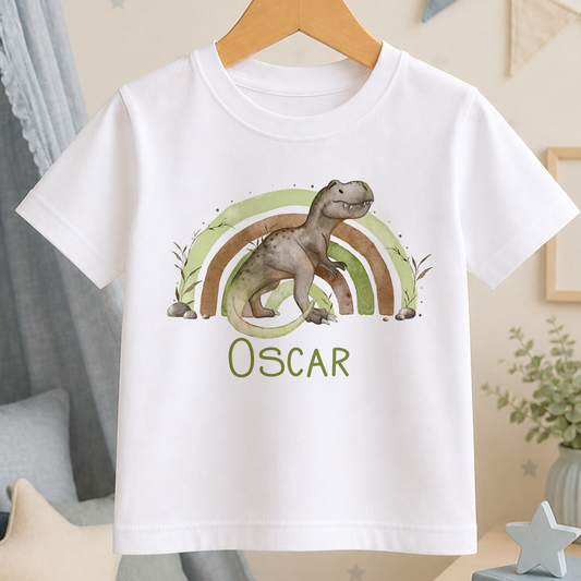 A white t-shirt with a dinosaur graphic and a rainbow design, along with the name "Oscar" printed on it.