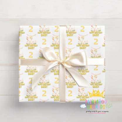 Personalised yellow duck balloon birthday wrapping paper wrapped around a gift box, tied and ready to give.