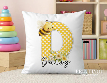 Personalised bee cushion shown resting on a bed