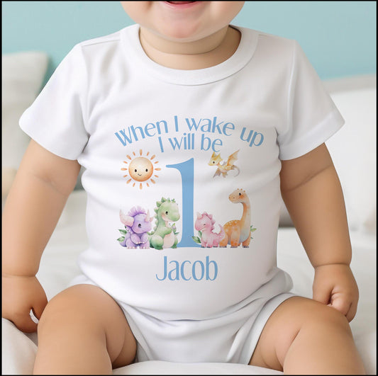 Personalised blue dinosaur bib, 'When I wake up I will be 1' design printed with baby's name.