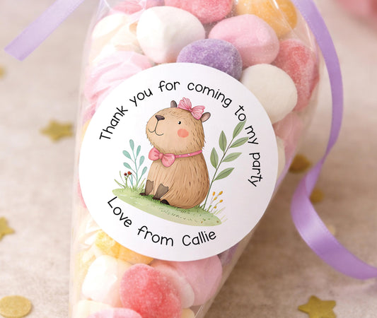Sheet of round personalised party stickers featuring a cute capybara design with a child's name