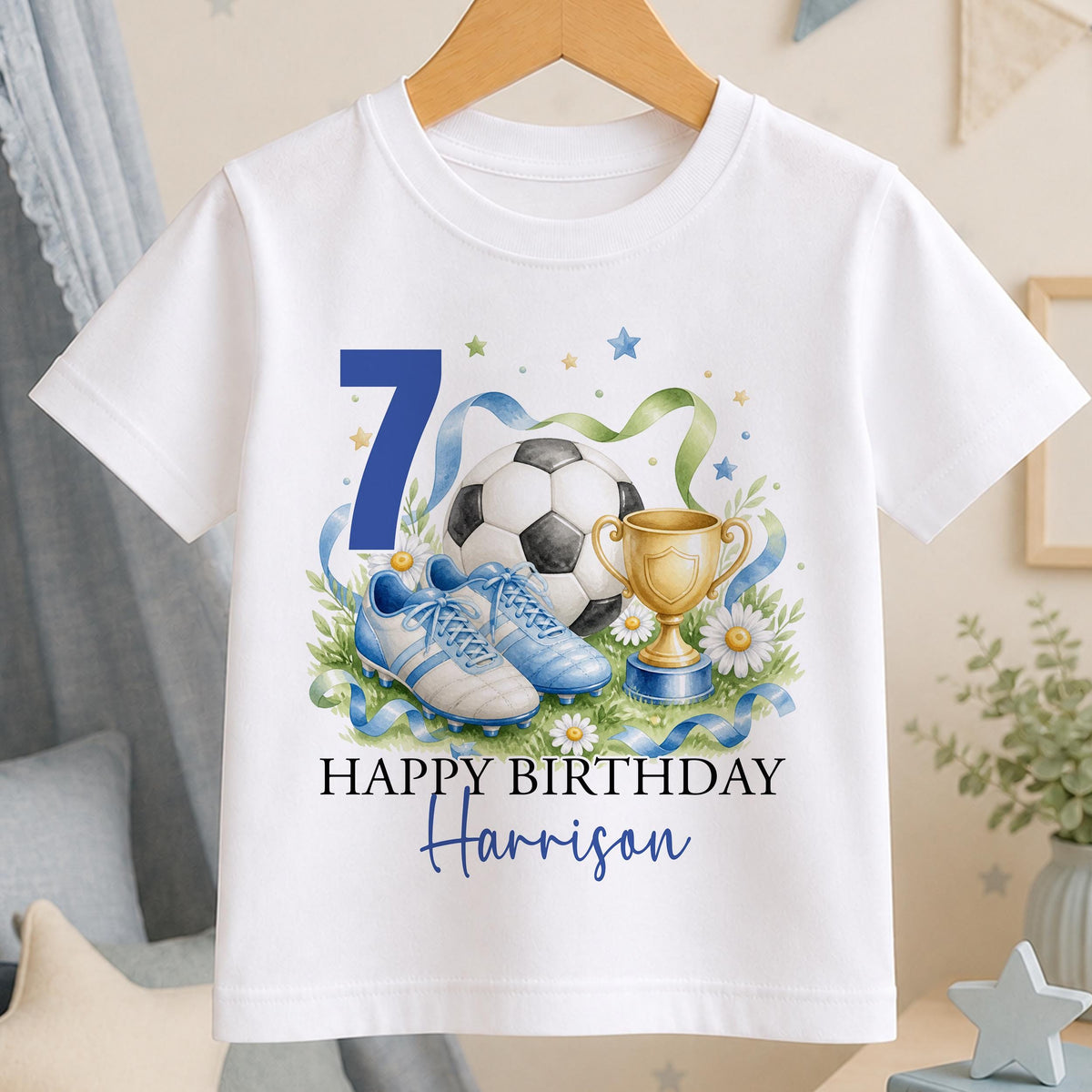 Personalised white t-shirt with a watercolour football, blue boots and a gold trophy, an age number and Happy Birthday above a name