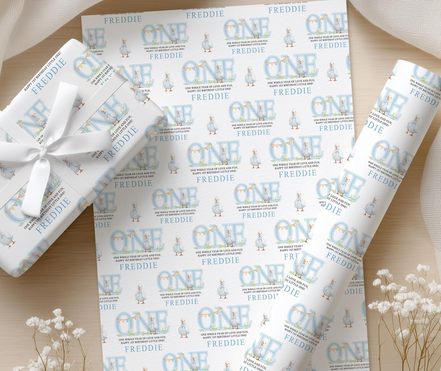 Close-up of the pastel blue duck wrapping paper pattern with the personalised name printed throughout.