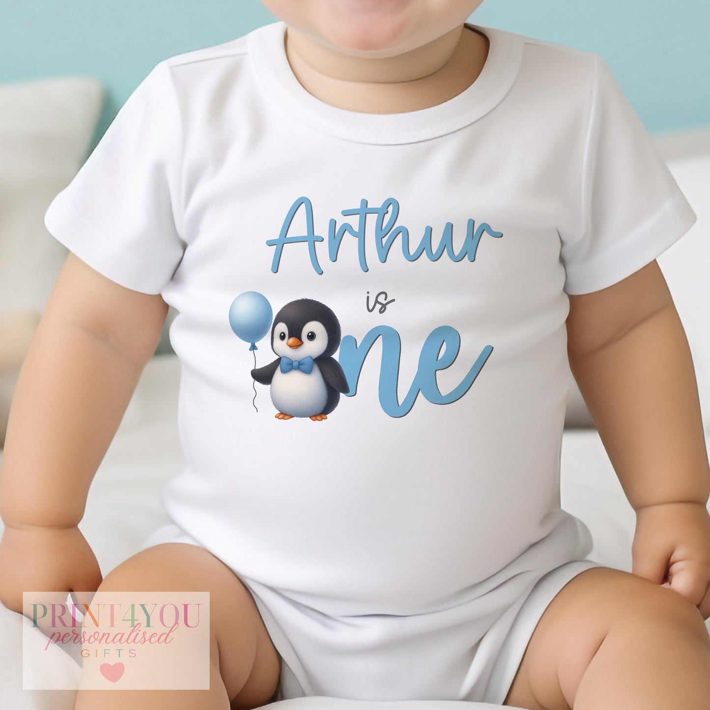 Personalised blue penguin first birthday bib with custom name printed on soft cotton