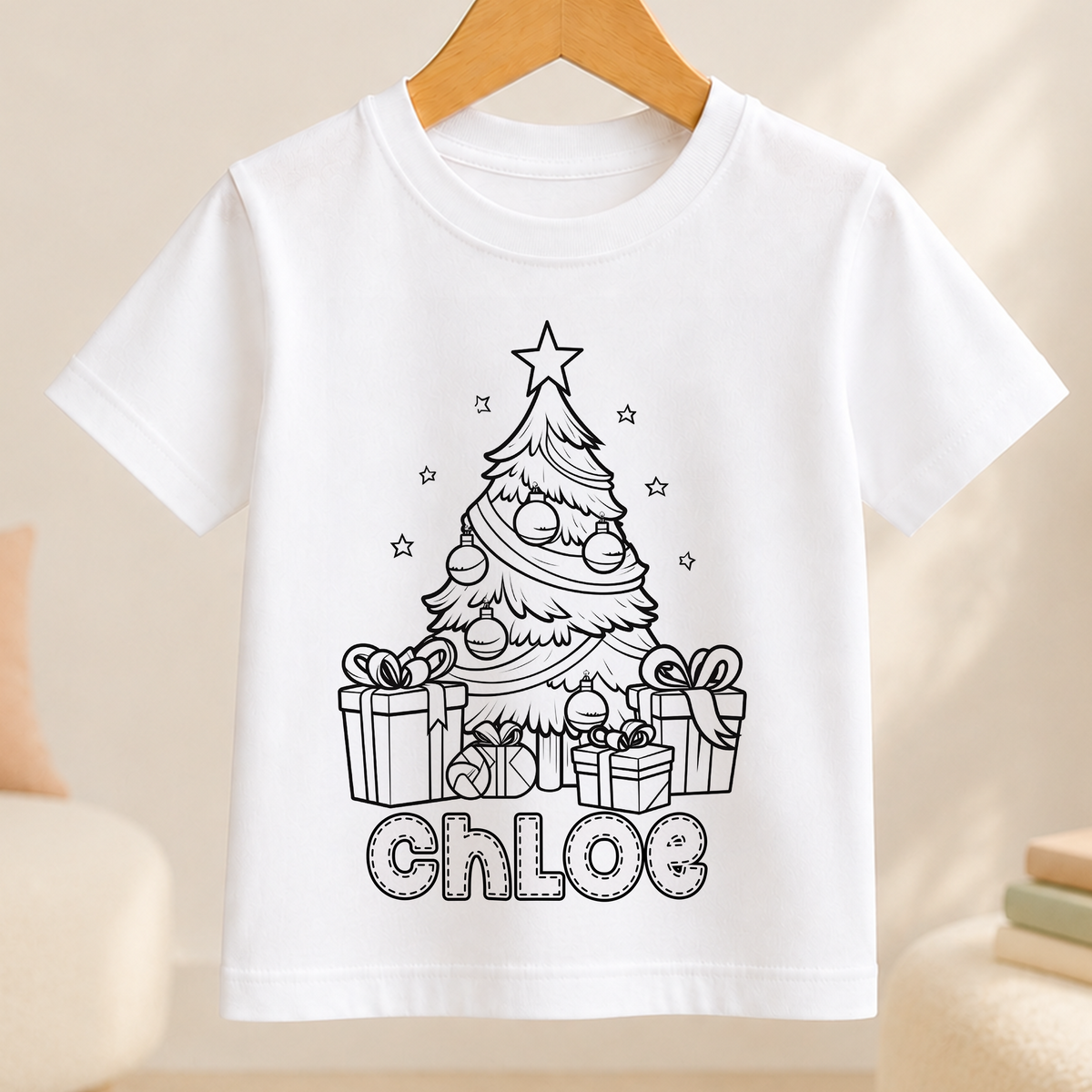 A white t-shirt with a black and white illustration of a Christmas tree and presents, along with the name "Chloe" written below it.
