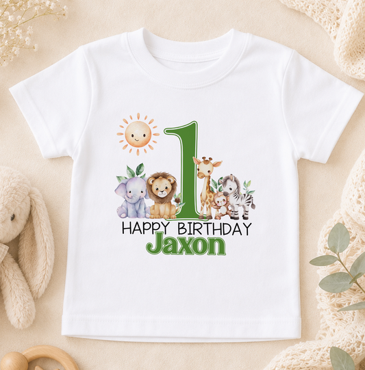 A white t-shirt with a graphic design featuring a sun, a lion, a giraffe, and a zebra, along with the text "Happy Birthday Jaxon".