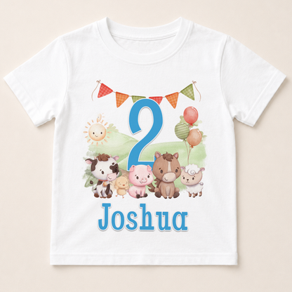 A white t-shirt with a cartoon image of various animals, including a horse, cow, pig, sheep, and a sun, along with a number 2 and the name " Joshua" printed on it.
