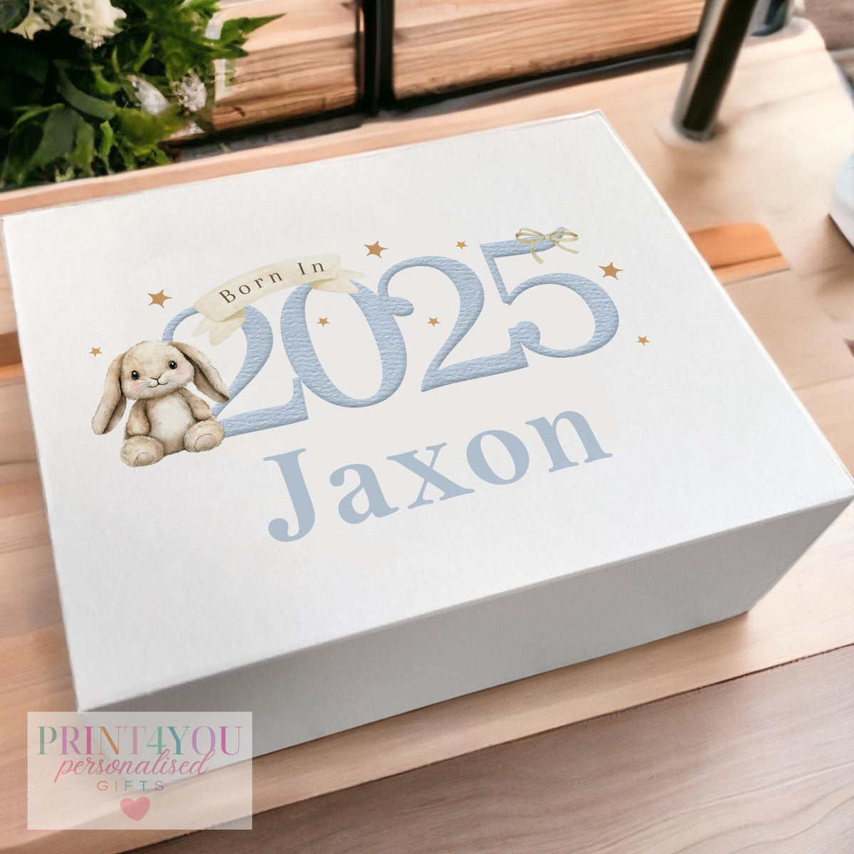 White magnetic-close keepsake box for a baby boy's first birthday, personalised with his name and printed with a blue bunny rabbit design and 'born in 2025' detail, shown in the medium 160 x 200 x 80mm size