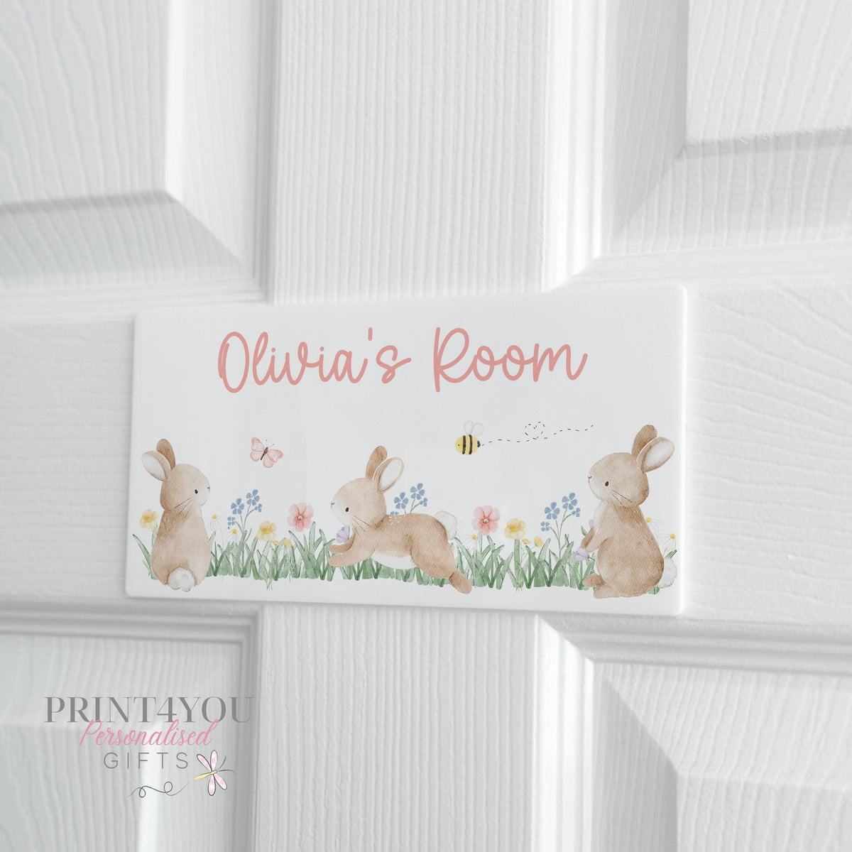 White acrylic bedroom door plaque with bunny, flower and butterfly design, personalised with child's name in pink cursive