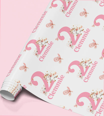 Pink and white unicorn wrapping paper personalised with the name 'Clennie', repeated across the pattern with butterflies