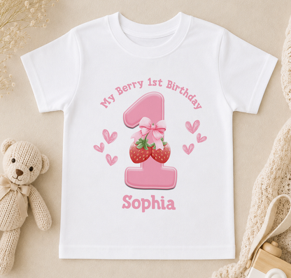 A white t-shirt with a pink number one and strawberries printed on it, along with the text "My Berry 1st Birthday Sophia".