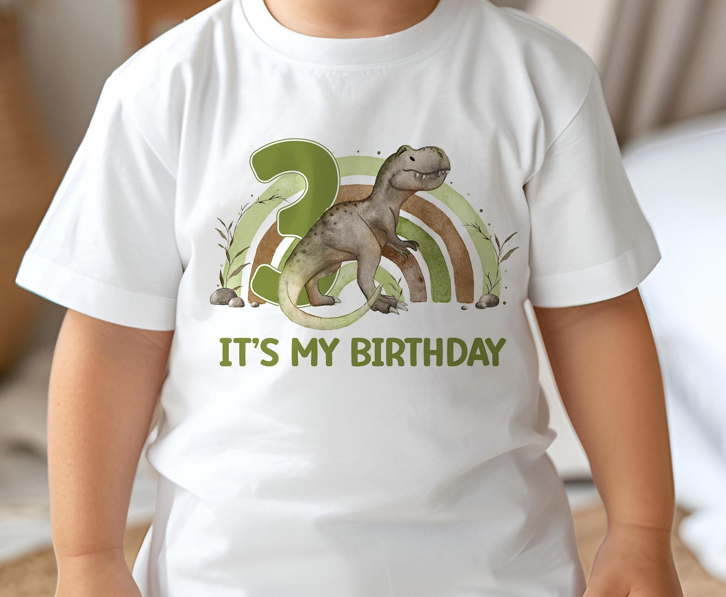 Baby wearing a white cotton birthday t-shirt printed with a T-Rex dinosaur design, size 6-12 months