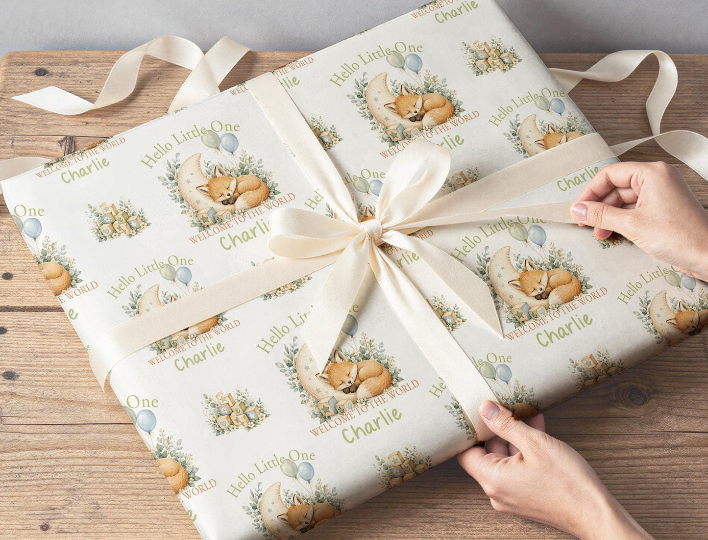 New baby gift wrapped in personalised Hello Little One sage green fox wrapping paper with custom name