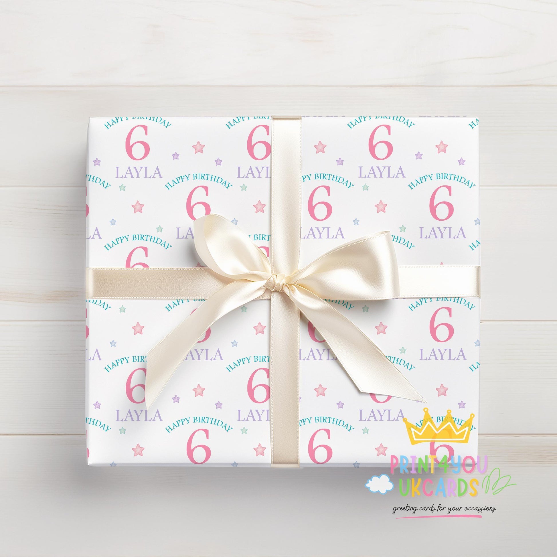 Personalised pastel stars wrapping paper laid flat, showing the full pattern with custom name and age.