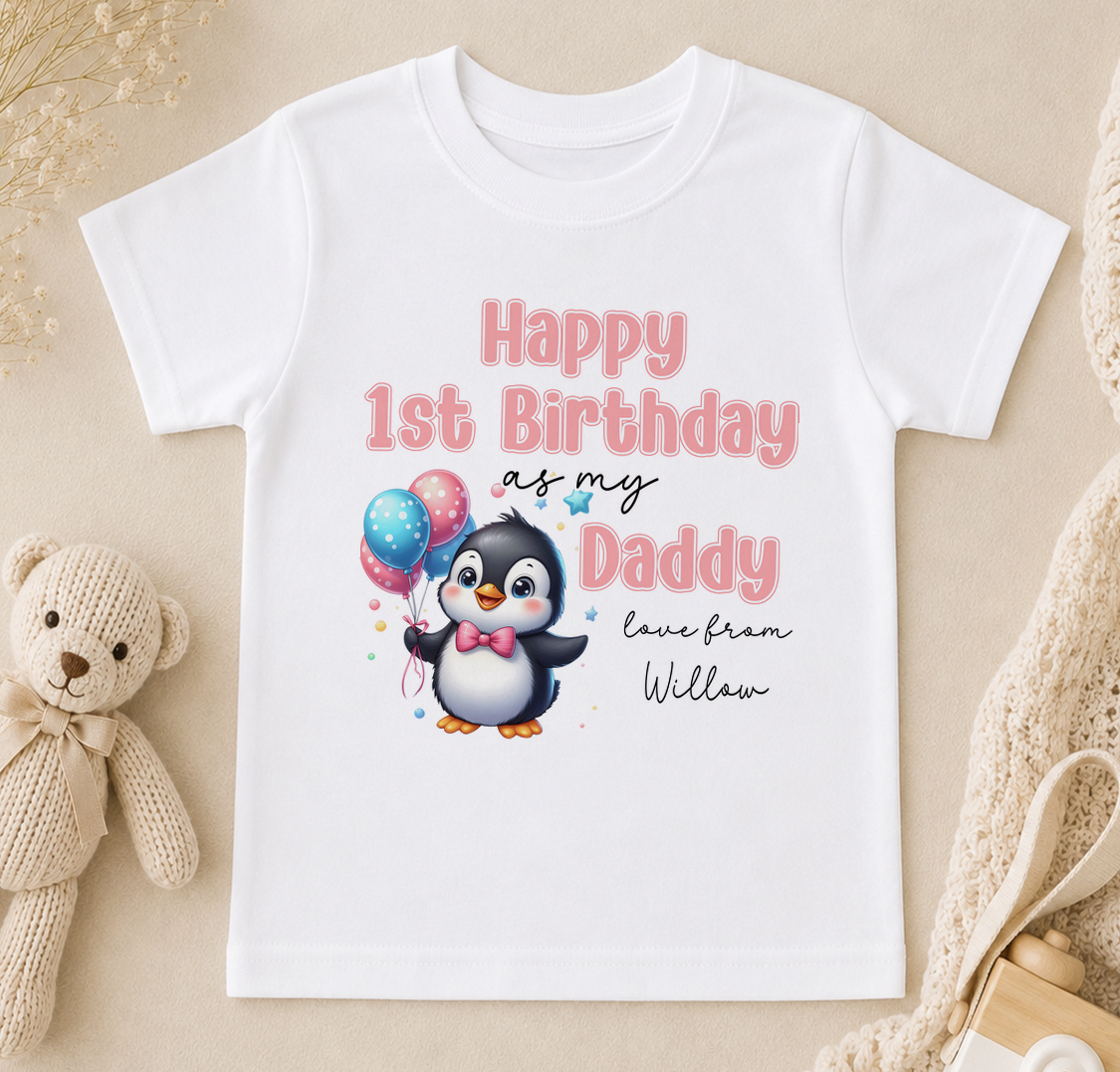 A white t-shirt with a cartoon penguin and text that reads "Happy 1st Birthday as my Daddy love from William" printed on it.