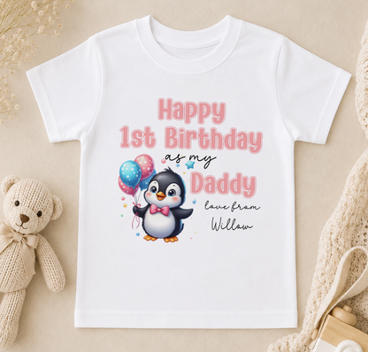 A white t-shirt with a cartoon penguin and text that reads "Happy 1st Birthday as my Daddy love from William" printed on it.