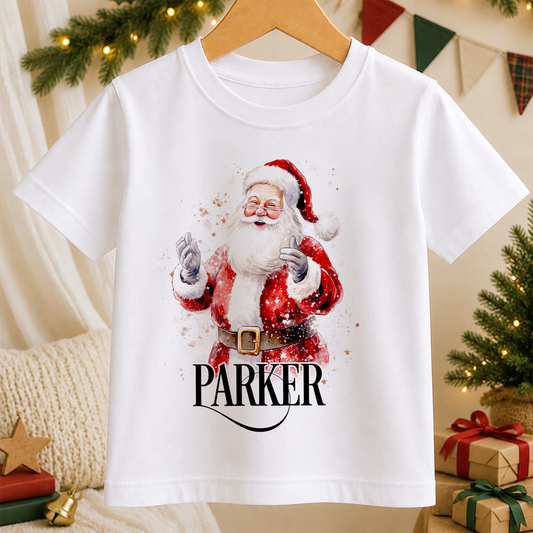 A white t-shirt with a printed image of Santa Claus and the name "Parker" below it.