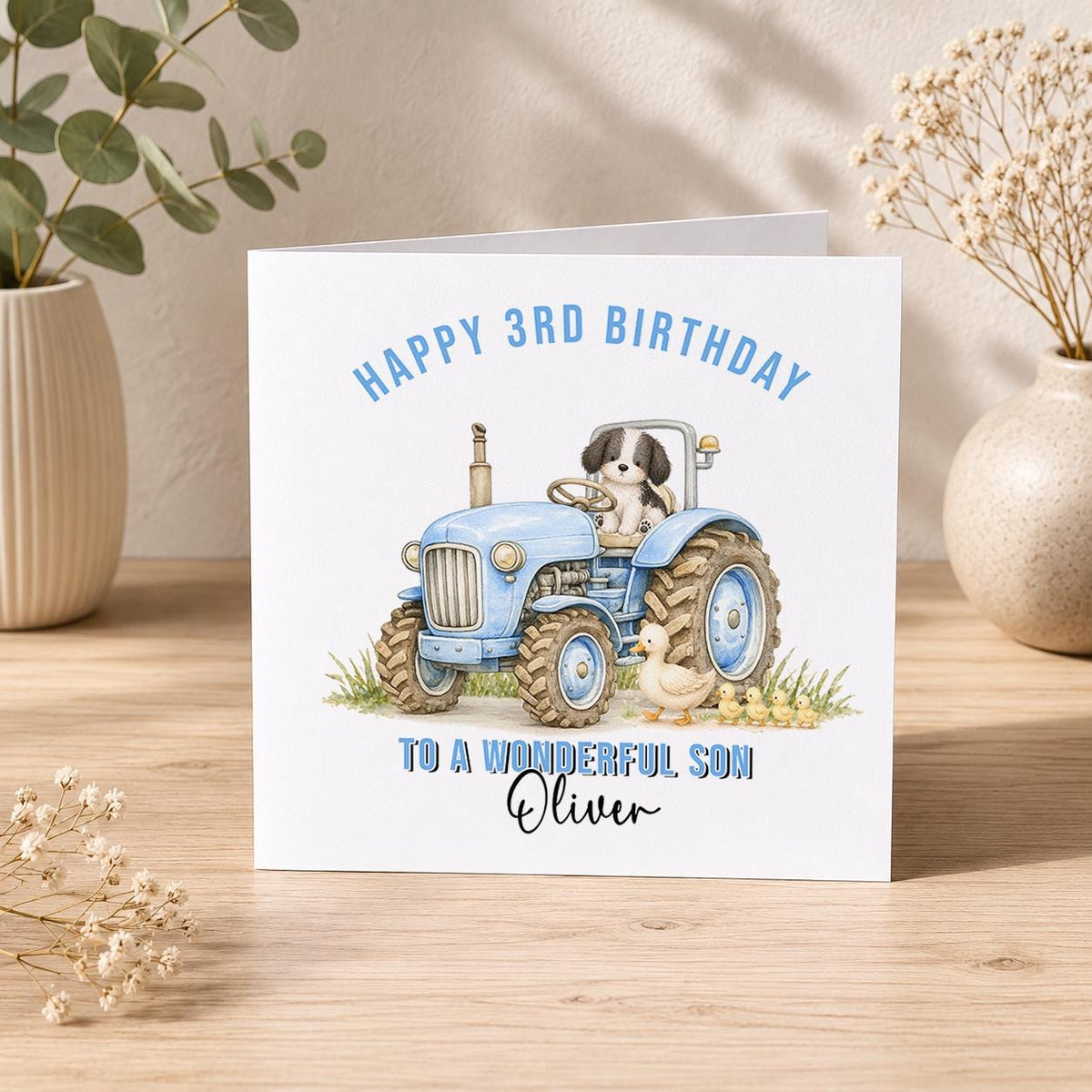 Square farmyard-themed birthday card shown with a blue tractor design, ready for personalisation