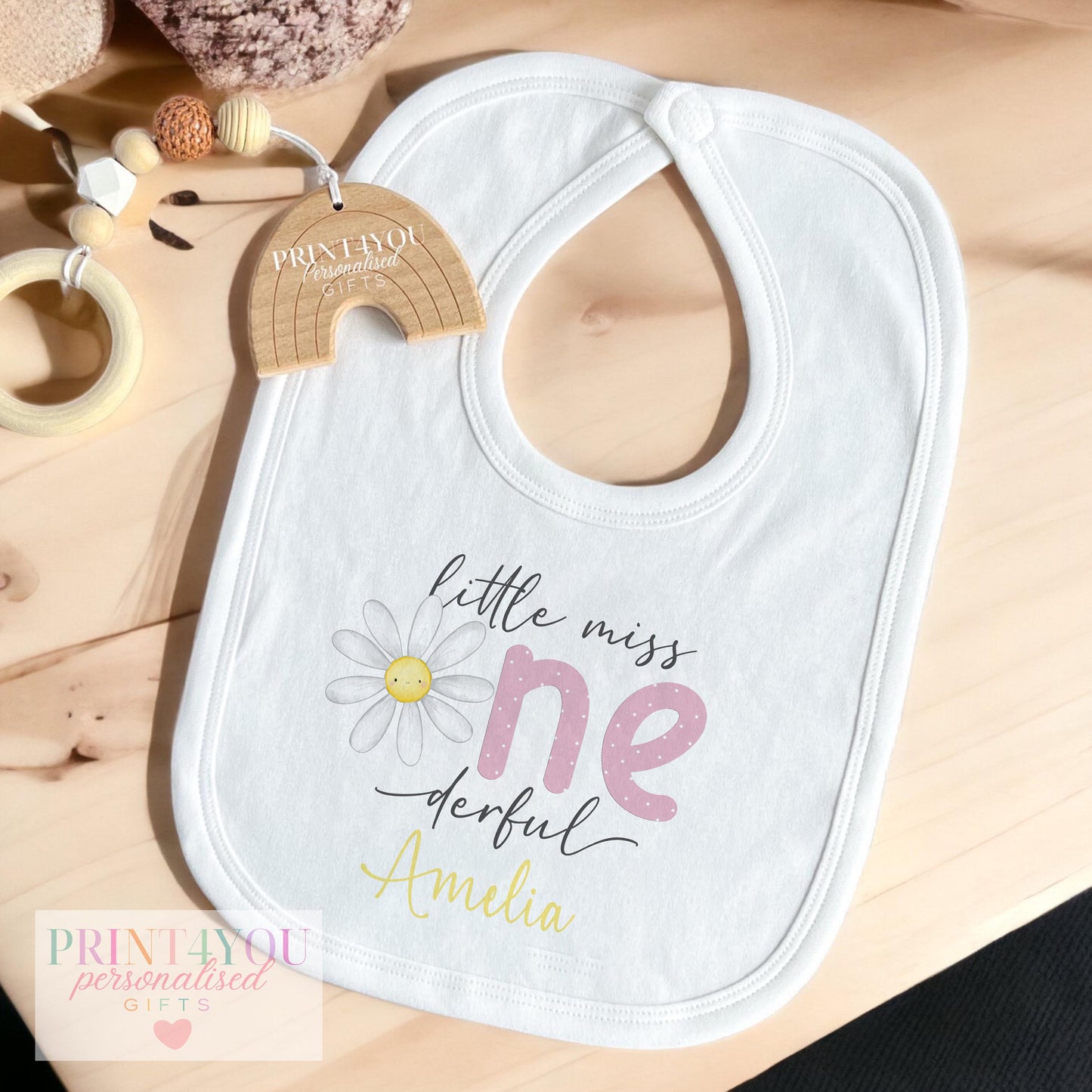 Personalised Little Miss One-derful daisy bib, laid out to show the polka-dot lettering and name print.