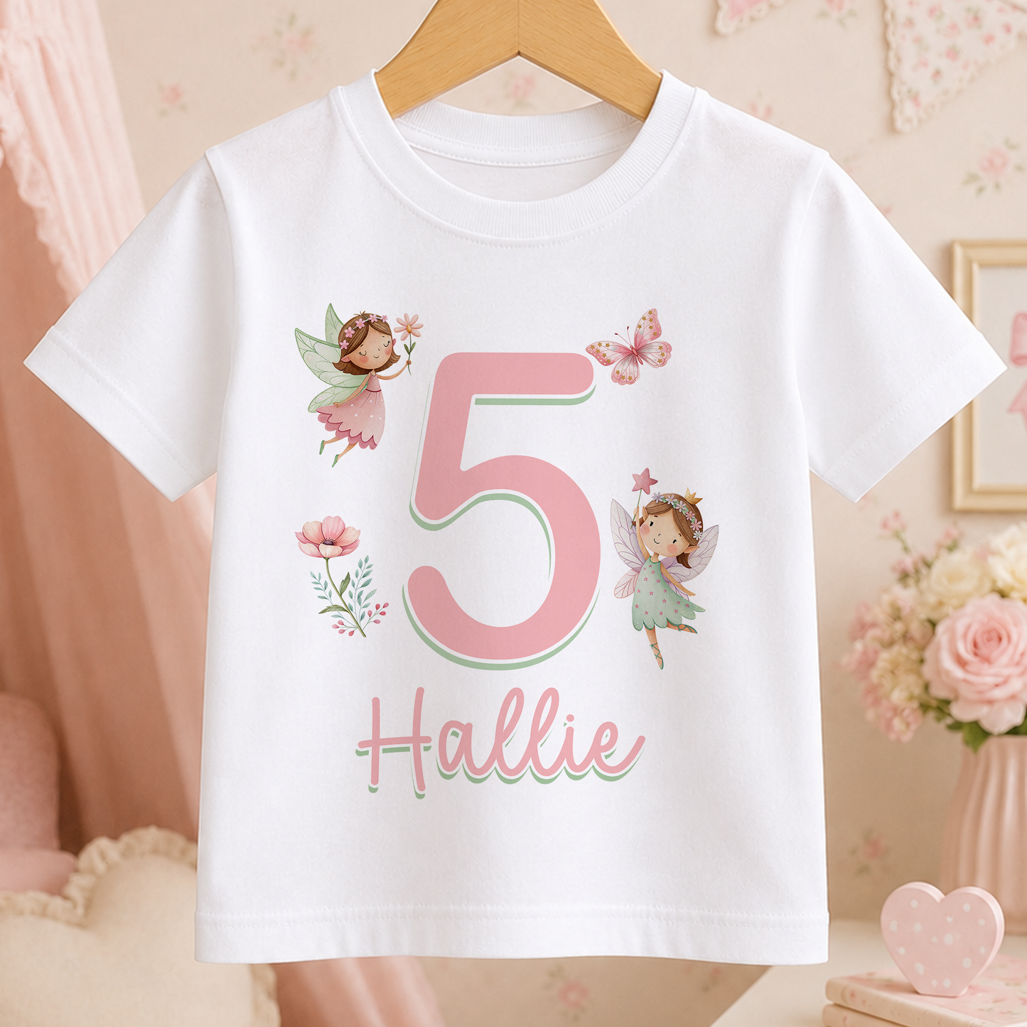 A white t-shirt with a pink number 5 and a fairy design, along with the name "Hollie" written below it.