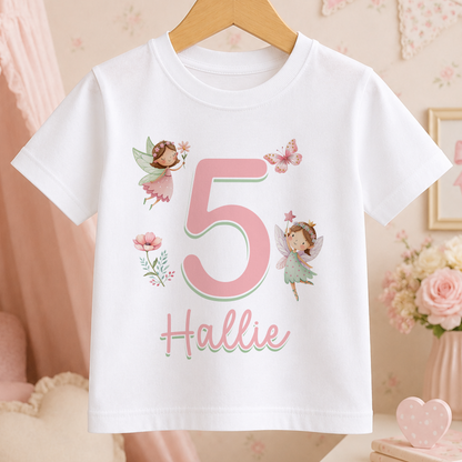 A white t-shirt with a pink number 5 and a fairy design, along with the name "Hollie" written below it.