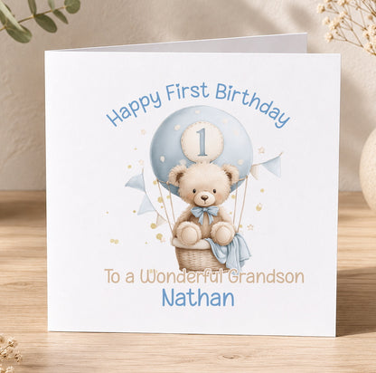 Square 1st birthday card featuring a teddy bear and hot air balloon design, personalised with the child's name for a son's first birthday.