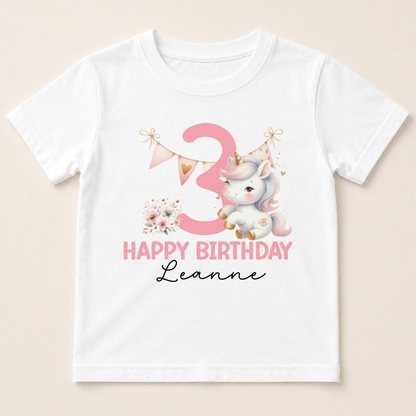 A white t-shirt with a pink unicorn and the number 3 printed on it, along with the text "Happy Birthday Leanne".