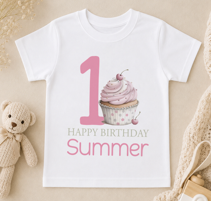 A white t-shirt with a graphic design featuring a cupcake and the number 1, along with the text "Happy Birthday Summer" printed on it.