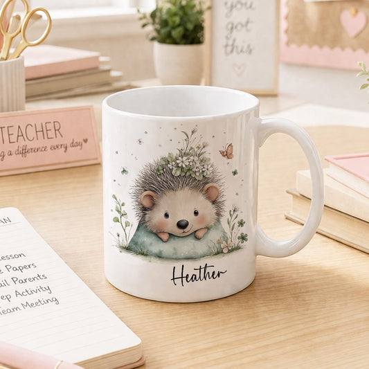 White ceramic mug printed with a smiling cartoon hedgehog and woodland leaves, personalised with a name
